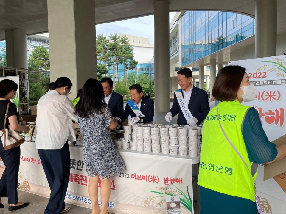 23일 정부세종청사에서 농협은행 김춘안 부행장과 직원들이 고객들에게 쌀과 컵 누룽지를 전달하고 있다. (사진=농협은행)